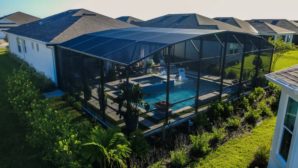 Elevated view of the screened pool lanai behind the home — pool, screen enclosure, and outdoor living in Melbourne, Florida