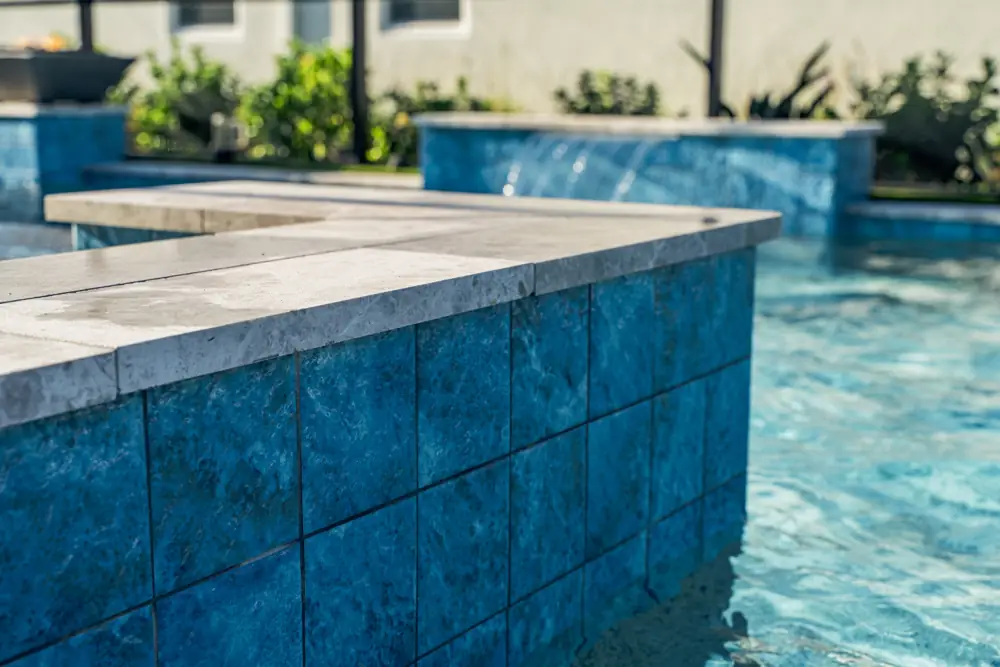Blue tile spa walls with travertine coping