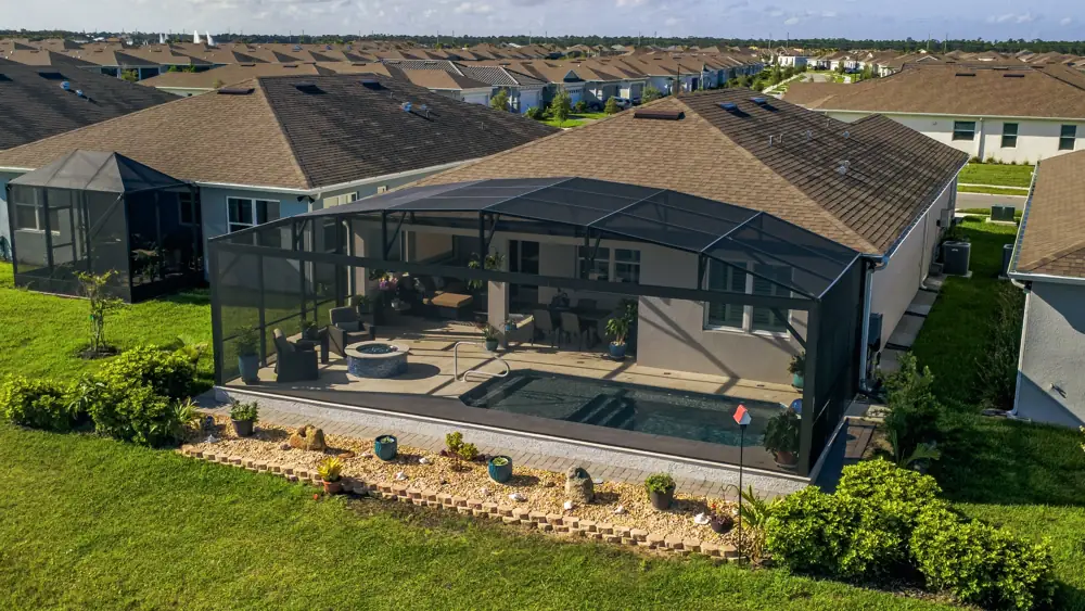Aerial of a screened pool lanai behind the home