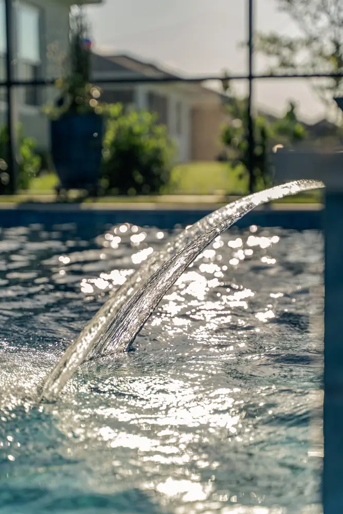 Laminar water jet arcing into the pool