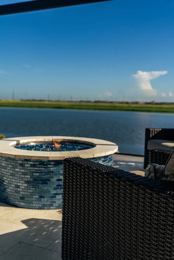 Fire pit flame beside the lake and patio seating