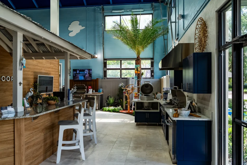 Inside the Lake Mary Design Center — outdoor kitchen displays and the tiki bar under the showroom palm