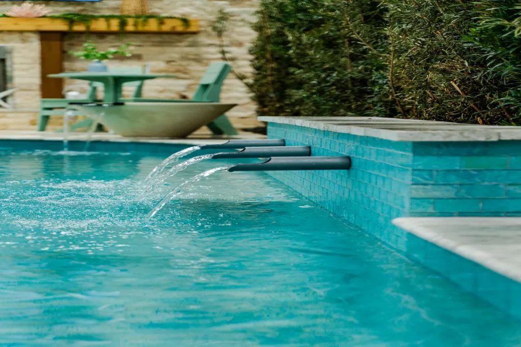 Scupper water feature spilling into the display pool beside a fire bowl